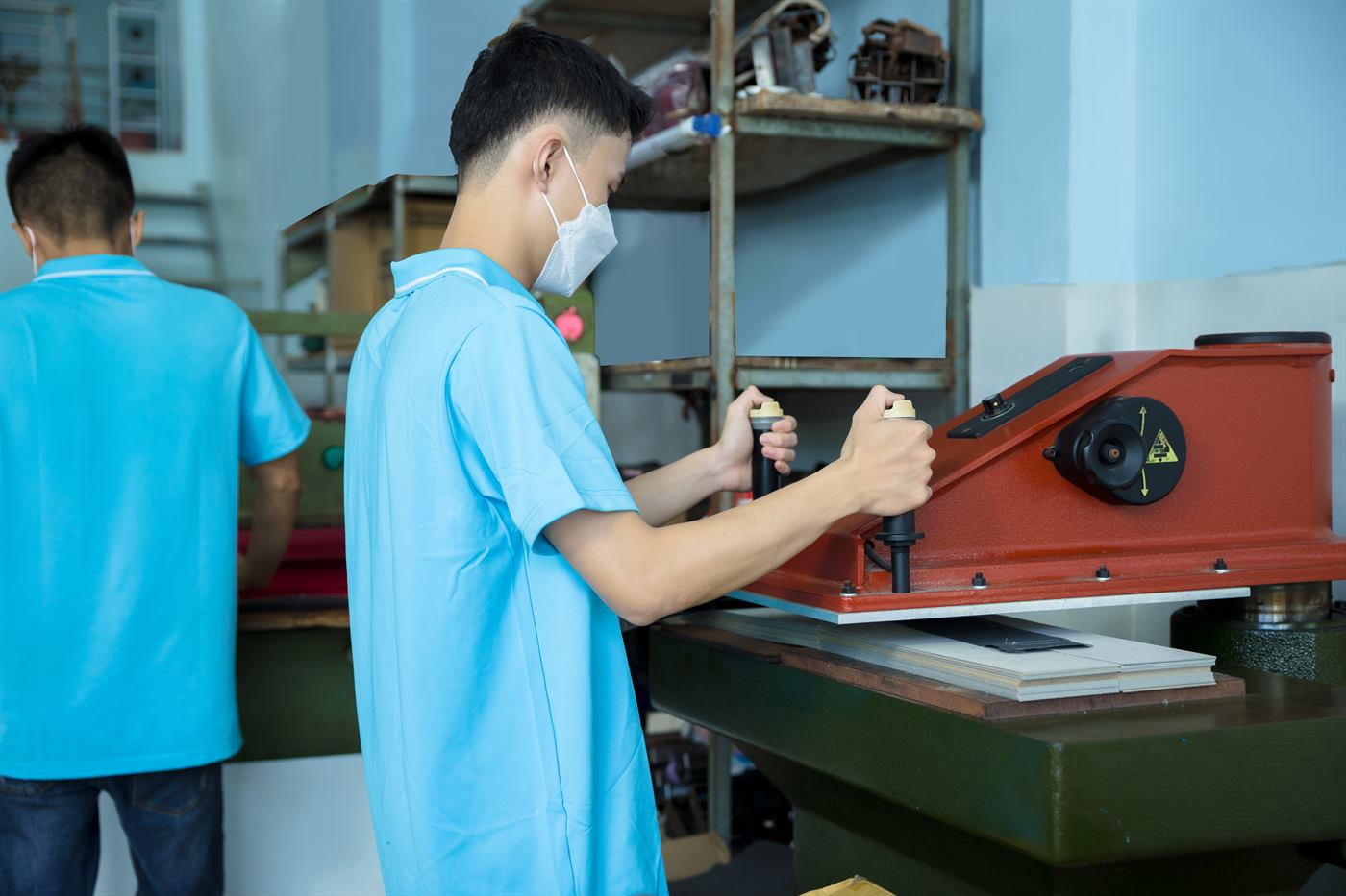 ホアンニャット工房のプレス機で作業する職人